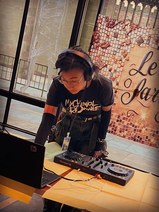 young person leaning over a DJ