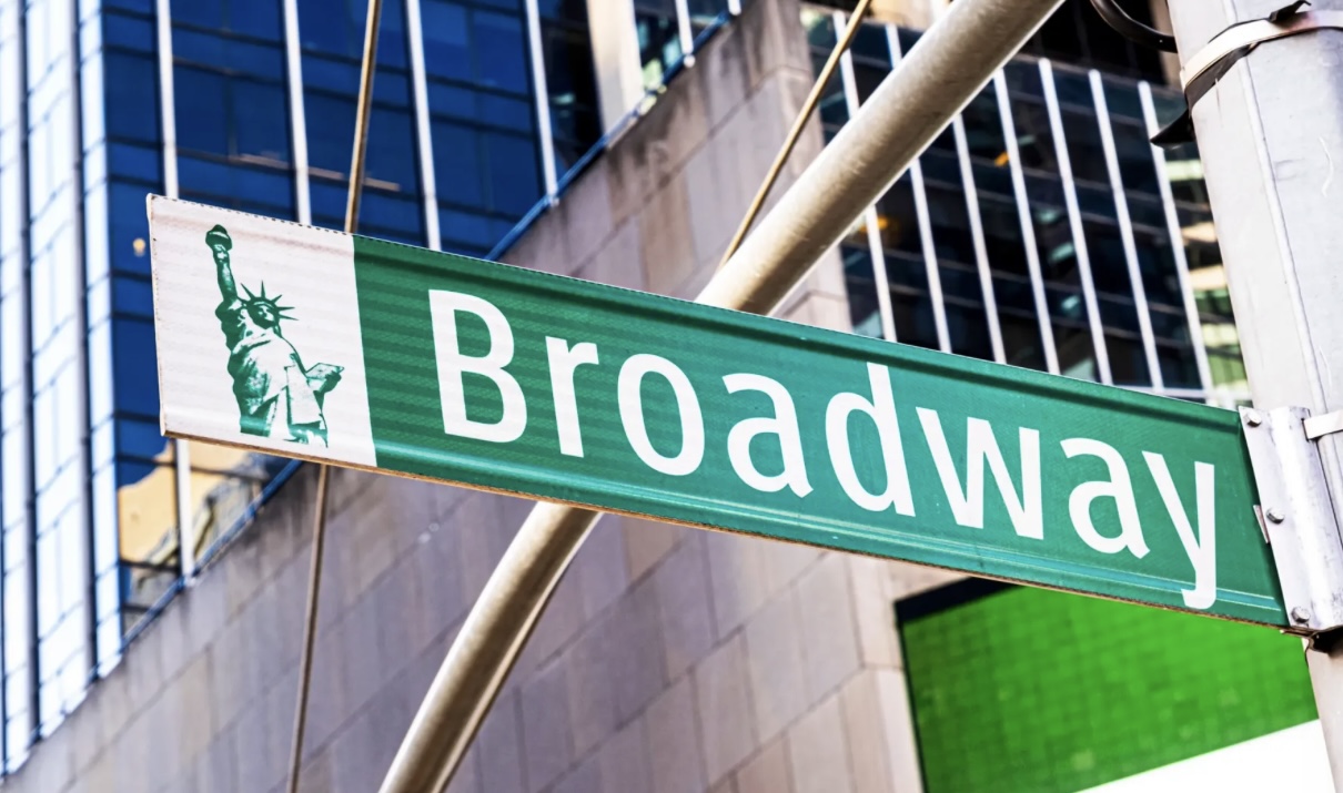 a green Broadway street sign in New York city