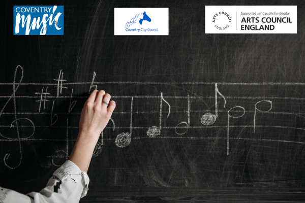 hand writing musical notation on a blackboard