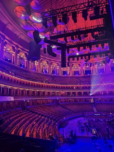 Picture of the inside of a empty Royal Albert hall lit with purple and blue lights