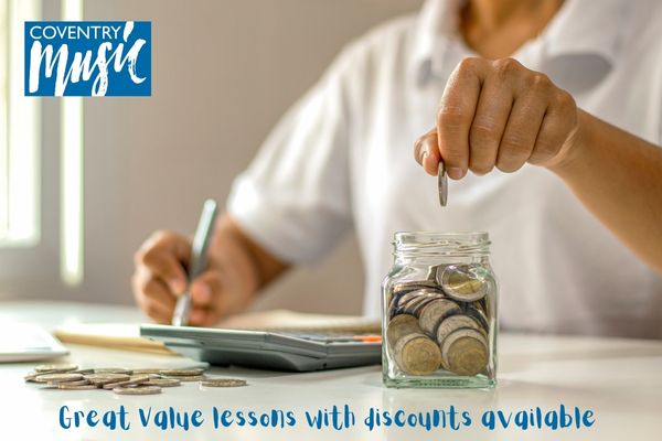 person counting coins into a jar with a calculator on a desk