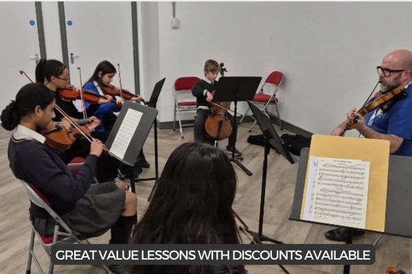 school children playing violins in a group setting
